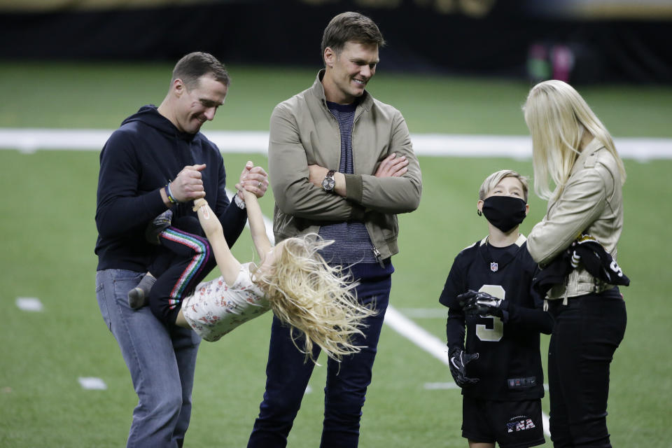 New Orleans Saints quarterback Drew Brees, left, plays with his children as Tampa Bay Buccaneers quarterback Tom Brady speaks with Brittany Brees after an NFL divisional round playoff football game between the New Orleans Saints and the Tampa Bay Buccaneers, Sunday, Jan. 17, 2021, in New Orleans. The Tampa Bay Buccaneers won 30-20. (AP Photo/Butch Dill)