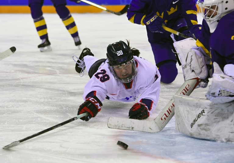 Unified Korea's Lee Jingyu (L) tries to shoot against Sweden's Sarah Berglind (R) in the women's play-off classifications (7-8) at Pyeongchang 2018