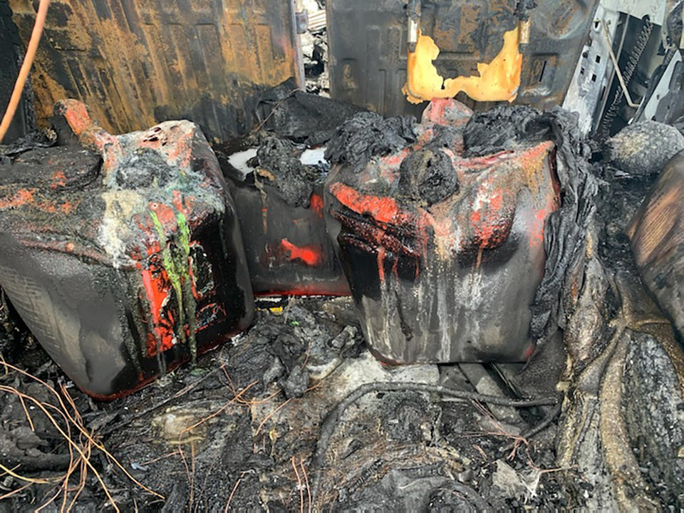 In this photo provided by Citrus County Fire Rescue melted gas cans sit amongst the charred remains of a Hummer that was destroyed by fire shortly after the driver had filled up four 5-gallon (18-liter) gas containers on Wednesday, May 12, 2021, in Homosassa, Fla. Many authorities are warning of the dangers of hoarding gas as shortages at the pumps are spreading from the South to the Mid-Atlantic states, following a cyberattack that forced a shutdown of the nation’s largest gasoline pipeline. (Citrus County Fire Rescue via AP)