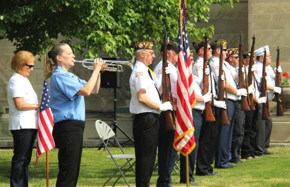 A member of the Pontiac Municipal Band performs Taps next to the American Legion/VFW Color Guard.