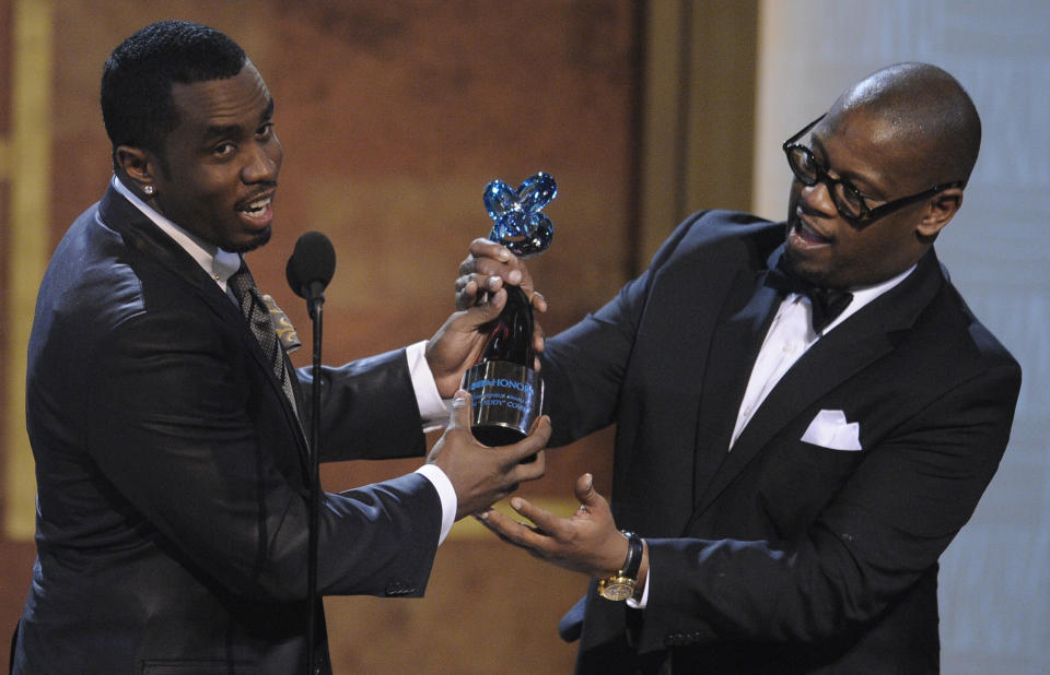 FILE - In this Jan. 16, 2010 file photo, media executive Andre Harrell, right, presents an award to Sean "Diddy" Combs at the Warner Theatre during the 2010 BET Hip Hop Honors in Washington. Harrell, the Uptown Records founder who shaped the sound of hip-hop and R&B in the late ’80s and ’90s with acts like Mary J. Blige and Heavy D and also launched the career of mogul Sean “Diddy” Combs, has died, several members of the music community revealed late Friday, May 8, 2020. He was 59. (AP Photo/Nick Wass)