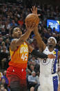 Utah Jazz guard Donovan Mitchell (45) lays the ball up as Indiana Pacers forward Justin Holiday (8) defends in the second half of an NBA basketball game Monday, Jan. 20, 2020, in Salt Lake City. (AP Photo/Rick Bowmer)