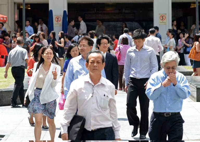 Pedestrians walk down a street in downtown financial district in Singapore on January 29, 2013. In a white (policy) paper on population, the government said Singaporeans' flagging birth rates -- which have been below replacement levels for more than three decades -- necessitated immigration into the prosperous Southeast Asian nation