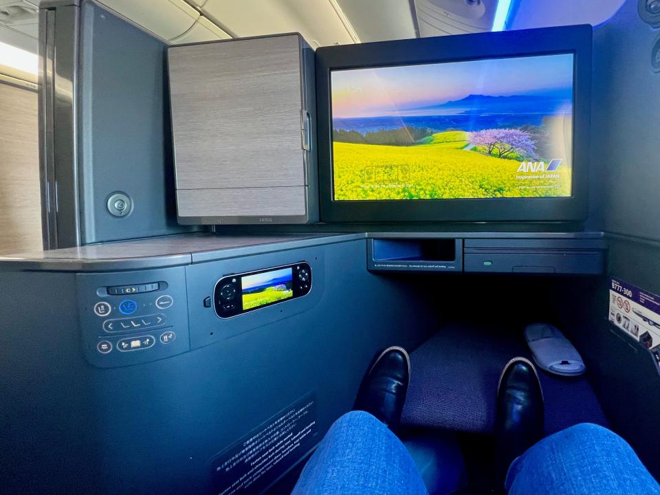 A view of the author's legs on the footrest of "The Room" business class on ANA.