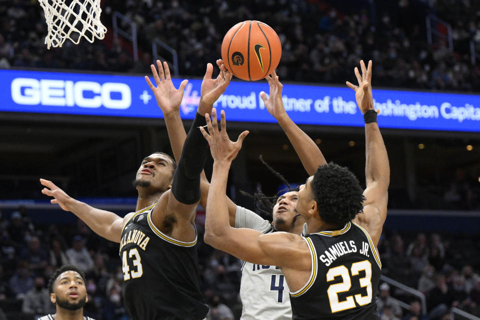 Villanova forward Eric Dixon (43) and forward Jermaine Samuels (23) battle for th eball against Georgetown forward Jalin Billingsley (4) during the first half of an NCAA college basketball game, Saturday, Jan. 22, 2022, in Washington. (AP Photo/Nick Wass)