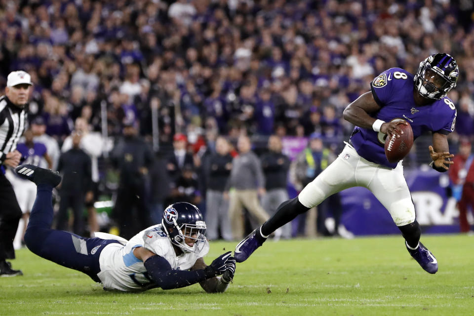 Baltimore Ravens quarterback Lamar Jackson (8) slips away from Tennessee Titans linebacker Harold Landry (58) during the first half an NFL divisional playoff football game, Saturday, Jan. 11, 2020, in Baltimore. (AP Photo/Julio Cortez)