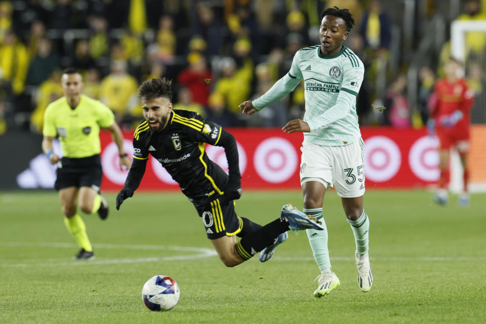 Atlanta United's Ajani Fortune, right, trips Columbus Crew's Diego Rossi, front left, during the second half of an MLS playoff soccer match Sunday, Nov. 12, 2023, in Columbus, Ohio. (AP Photo/Jay LaPrete)