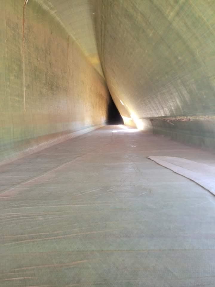 Inside a long, narrowing tunnel with light visible at the far end