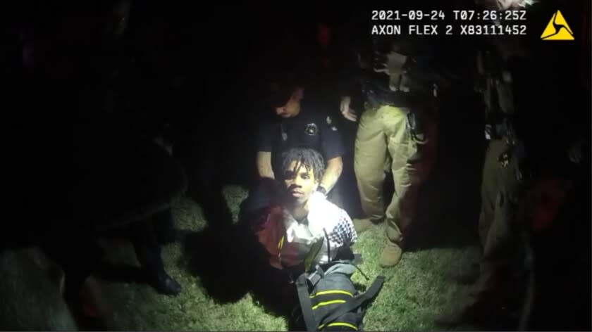 In this image from body camera video provided by Sedgwick County, police put Cedric "C.J." Lofton, 17, into a body-length restraining device called a WRAP outside his home in Wichita, Kan., on Sept. 24, 2021. His foster father, unable to deal with a teen who seemed to be in the throes of schizophrenia, had called Wichita police. When they arrived, Cedric refused to leave the porch and go with them; he was obstinate but afraid, meek but frantic. (Sedgwick County via AP)