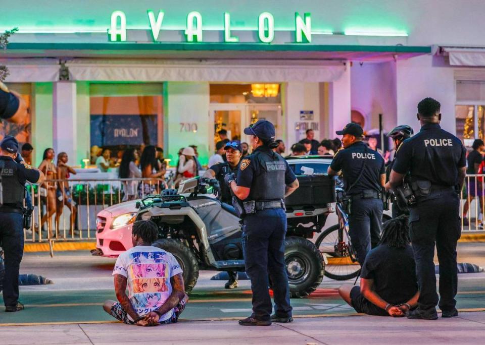 Miami Beach police officers detain men on Ocean Drive across from the Avalon Hotel during spring break on Miami Beach, Florida on Saturday, March 16, 2024.