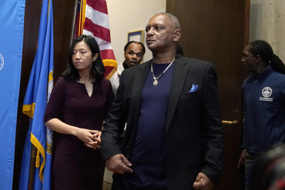 Alan Swanson, center, arrives at a news conference at Boston City Hall with Boston Mayor Michelle Wu, left, Wednesday, Dec. 20, 2023, in Boston. During the news conference Wu issued a formal apology to Swanson and Willie Bennett, not shown, for their wrongful arrests following the 1989 death of Carol Stuart, whose husband, Charles Stuart, had orchestrated her murder. (AP Photo/Steven Senne)