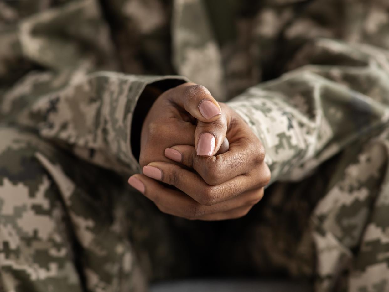 Clasped Hands Of Black Soldier Woman In Camouflage Uniform, Closeup Shot
