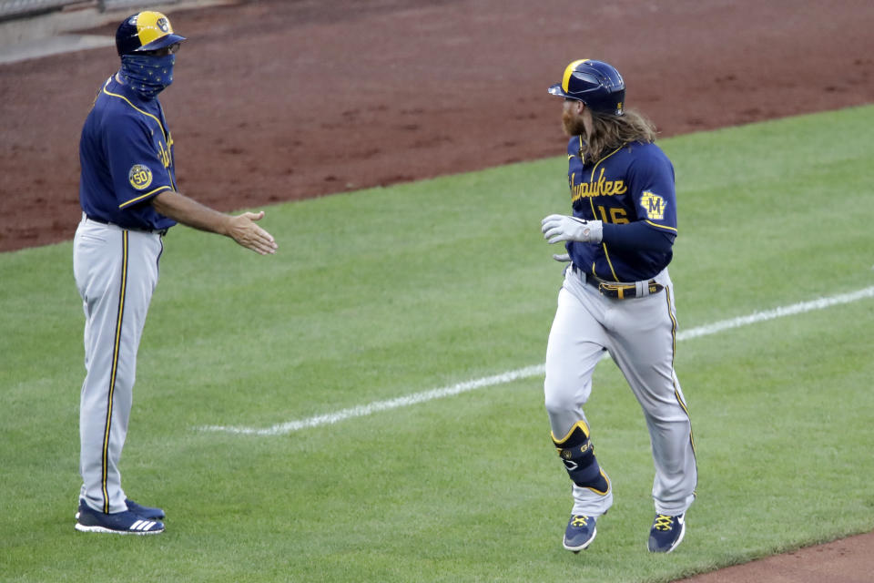 Milwaukee Brewers' Ben Gamel (16) rounds third past the outstretched hand of coach Ed Sedar after hitting a two-run home run off Pittsburgh Pirates starting pitcher Joe Musgrove during the third inning of a baseball game in Pittsburgh, Wednesday, July 29, 2020. (AP Photo/Gene J. Puskar)