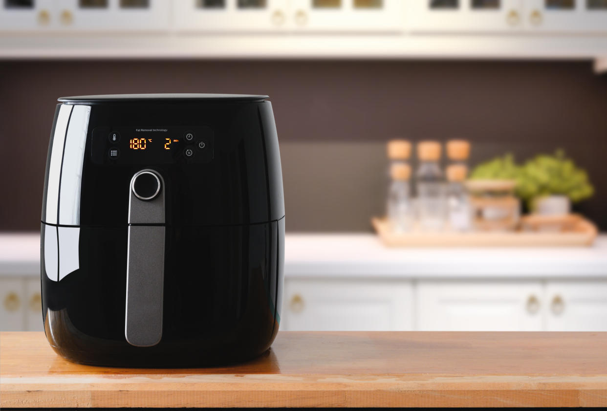 Air fryer machine cooking potato fried in kitchen.  Lifestyle of new normal cooking.