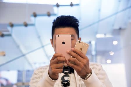 A man takes pictures as the Apple iPhone 6s and 6s Plus go on sale at an Apple Store in Beijing, China, in this September 25, 2015 file photo. REUTERS/Damir Sagolj/Files