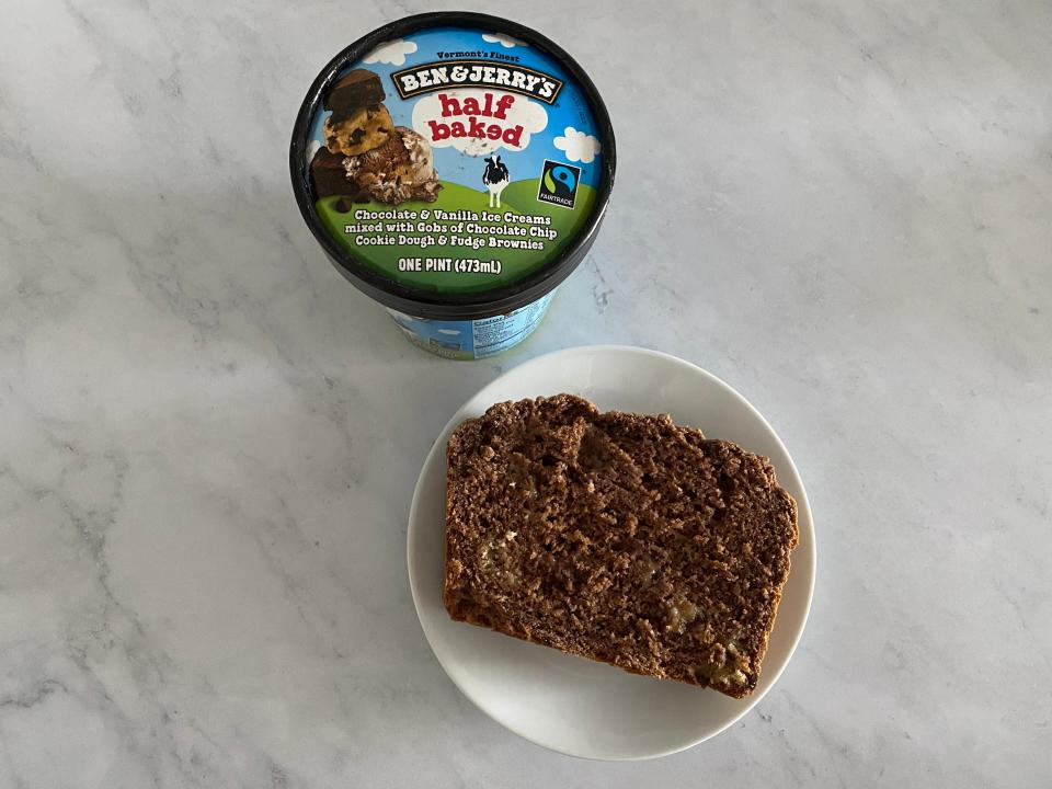 half baked pint next to a plated slice of the brown loaf on a white countertop