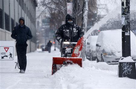 A man clears snow with a snow blower in the South Bronx section of New York City, January 3, 2014. REUTERS/Mike Segar