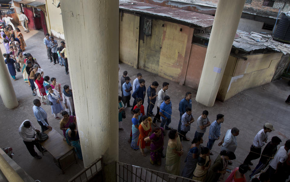 Indian people stand in queue to cast their votes in a polling center during the third phase of general election in Gauhati, India, Tuesday, April 23, 2019. Indians are voting Tuesday in the third phase of the general elections with campaigning by Prime Minister Narendra Modi's Hindu nationalist party and the opposition marred by bitter accusations and acrimony. The voting over seven phases ends May 19, with counting scheduled for May 23. (AP Photo/Anupam Nath)