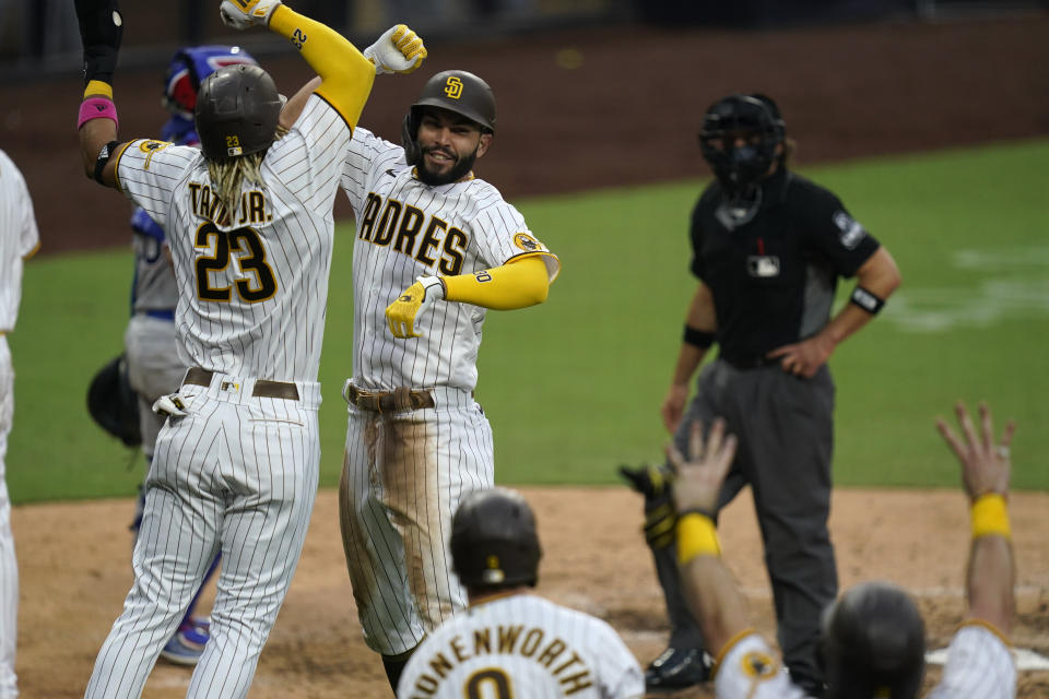 San Diego Padres' Eric Hosmer, facing camera, reacts with teammates after hitting a grand slam during the fifth inning of a baseball game against the Texas Rangers, Thursday, Aug. 20, 2020, in San Diego. (AP Photo/Gregory Bull)