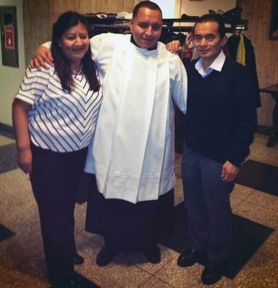 In this December 2014 handout provided by Rev. Joseph Dutan, Dutan poses with his mother, Ana, and father, Manuel at seminary in the Queens borough of New York. Rev. Joseph Dutan recently lost his father, Manuel Dutan, to coronavirus. (Courtesy of Joseph Dutan via AP)
