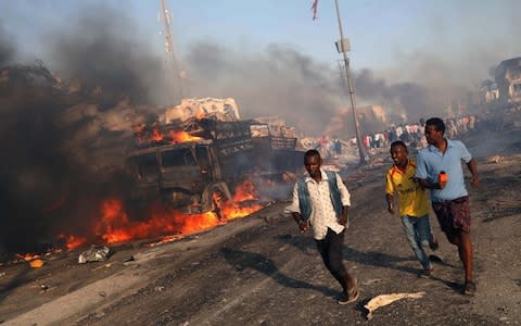 Civilians evacuate from the scene of an explosion in KM4 street in the Hodan district of Mogadishu - Credit: Reuters