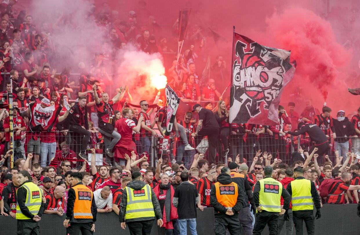 Bayern Leverkusen fans celebrate after the team defeats Werder Bremen to clinch the German Bundesliga title.