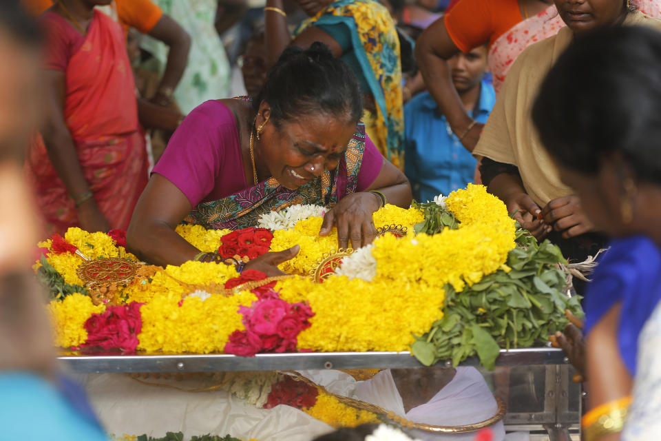 A relative of a man, who died after drinking illegally brewed liquor, cries over a casket containing his body in Kallakurichi district of the southern Indian state of Tamil Nadu, India, Thursday, June 20, 2024. The state's chief minister M K Stalin said the 34 died after consuming liquor that was tainted with methanol, according to the Press Trust of India news agency. (AP Photo/R. Parthibhan)