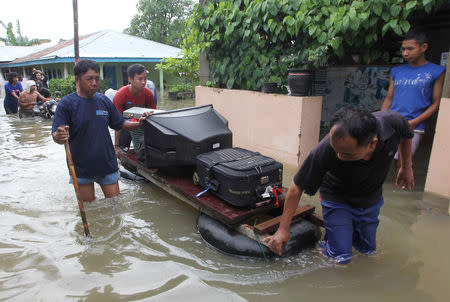 Residents carry their belongings with a raft through the flood in Bengkulu, Indonesia, April 27, 2019. Picture taken April 27, 2019. Antara Foto/David Muharmansyah/ via REUTERS