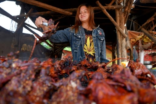 At a stall in Battambang town, Cambodia, rows of grilled field rats are displayed over burning charcoals