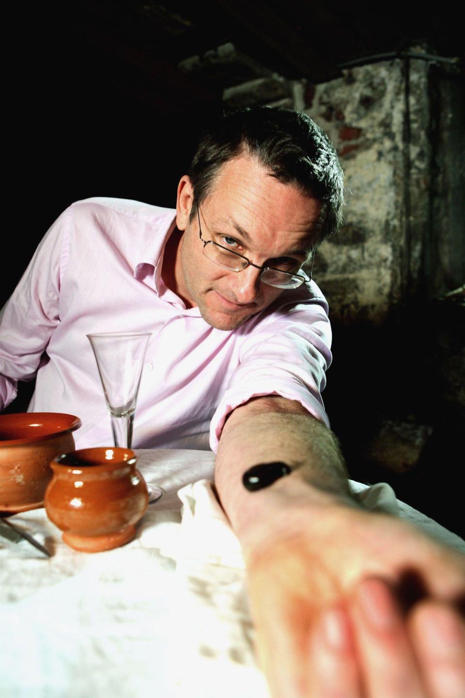 Michael Mosley posing with a blood sucking leech on his arm