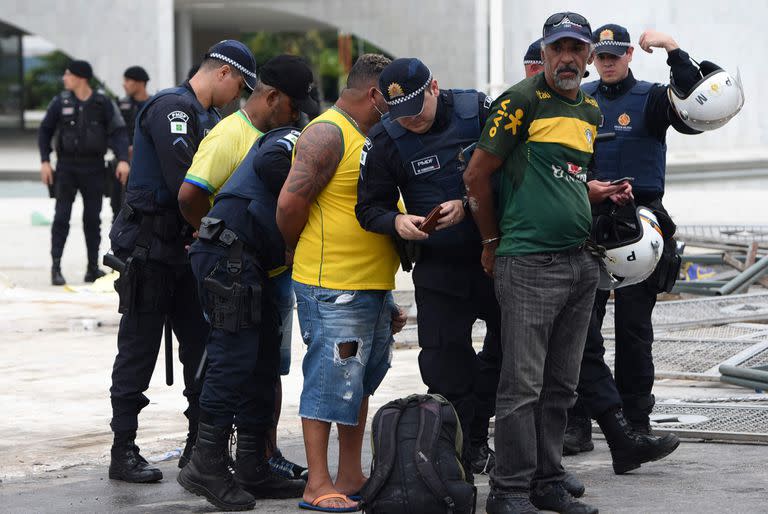 Las fuerzas de seguridad arrestan a los partidarios del expresidente brasileño Jair Bolsonaro después de retomar el control del Palacio Presidencial de Planalto en Brasilia