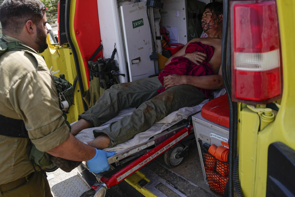 Israeli security forces in Kiryat Shoma, northern Israel, evacuate a wounded Thai man after he was hit by an anti-tank missile fired from Lebanon, in a nearby village on Monday, March 4, 2024. (AP Photo/Ariel Schalit)