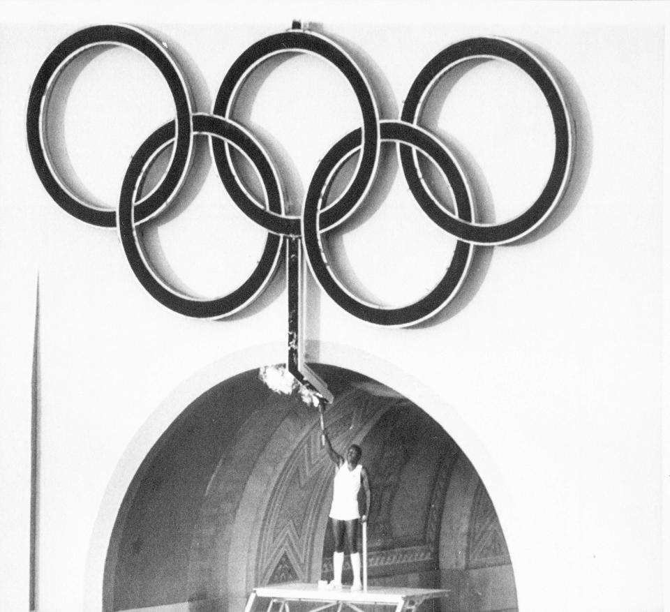 FILE - In this July 28, 1984, file photo, Rafer Johnson, winner of the gold medal for the decathlon in 1960, lights the Olympic torch during opening ceremonies of the Olympic Games in Los Angeles. Rafer Johnson, who won the decathlon at the 1960 Rome Olympics and helped subdue Robert F. Kennedy's assassin in 1968, died Wednesday, Dec. 2, 2020. He was 86. He died at his home in the Sherman Oaks section of Los Angeles, according to family friend Michael Roth. (AP Photo/FIle)