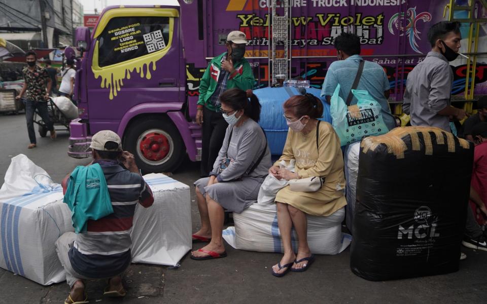 Women wear protective masks at a Jakarta market - Dimas Ardian/Bloomberg