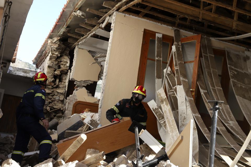 Firefighters search inside a damaged house after an earthquake in Damasi village, central Greece, Thursday, March 4, 2021. Fearful of returning to their homes, many thousands of people in central Greece spent the night outdoors after a powerful earthquake Wednesday, felt across the region leaving many damaged homes and public buildings.(AP Photo/Vaggelis Kousioras)