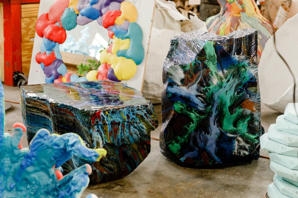Two Hunk tables from Gander’s Flow series are cut out of styrofoam with a chain saw, covered in fiberglass, and then coated in iridescent color-shifting resin which is poured on to create a striated effect.