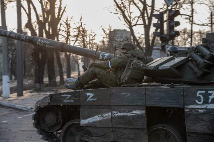 Russian soldiers sitting on a T-80 tank heading towards the Azovstal plant in Ukraine.