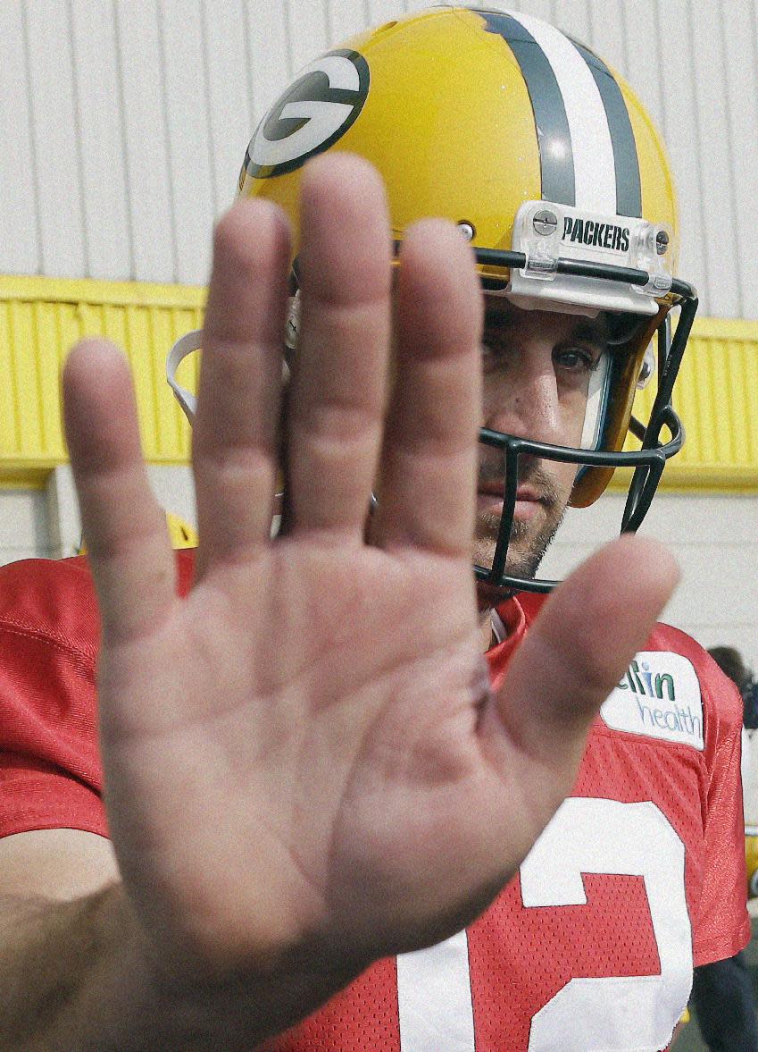 Green Bay Packers’ Aaron Rodgers tries to block the lens as he arrives for NFL football training camp Monday, July 28, 2014, in Green Bay, Wis. (AP Photo/Morry Gash)