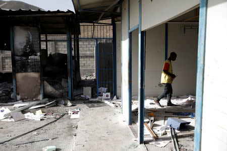 A boy walks inside destroyed customs facilities in Malpasse, Haiti, July 8, 2018. REUTERS/Andres Martinez Casares