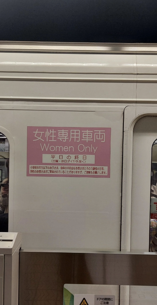 Sign on train indicating 'Women Only' carriage during specified times