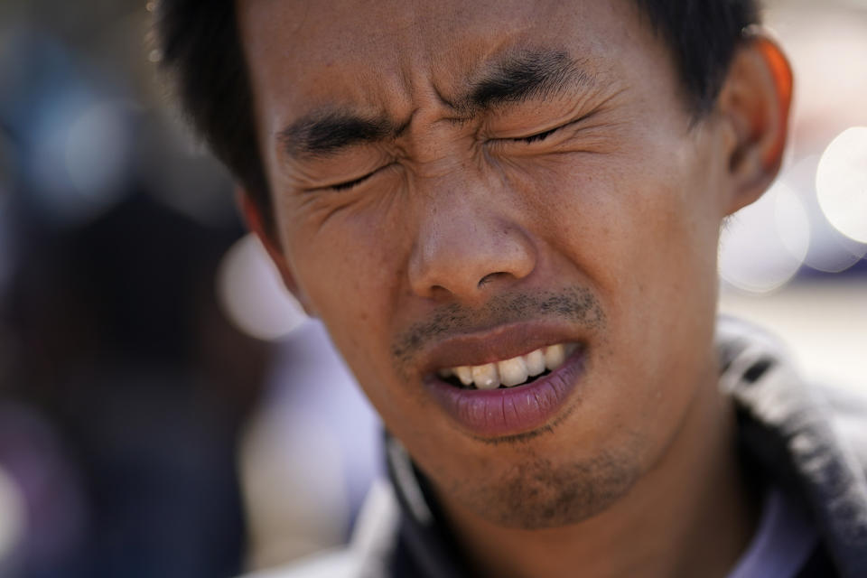 Deng Guangsen winces as he talks about his journey from his homeland China to crossing the United States border with Mexico, as he sits in a transit center after being dropped off by Border Patrol agents Wednesday, Oct. 18, 2023, in San Diego. A major influx of Chinese migration to the United States on a relatively new and perilous route through Panama's Darién Gap jungle has become increasingly popular thanks to social media. (AP Photo/Gregory Bull)