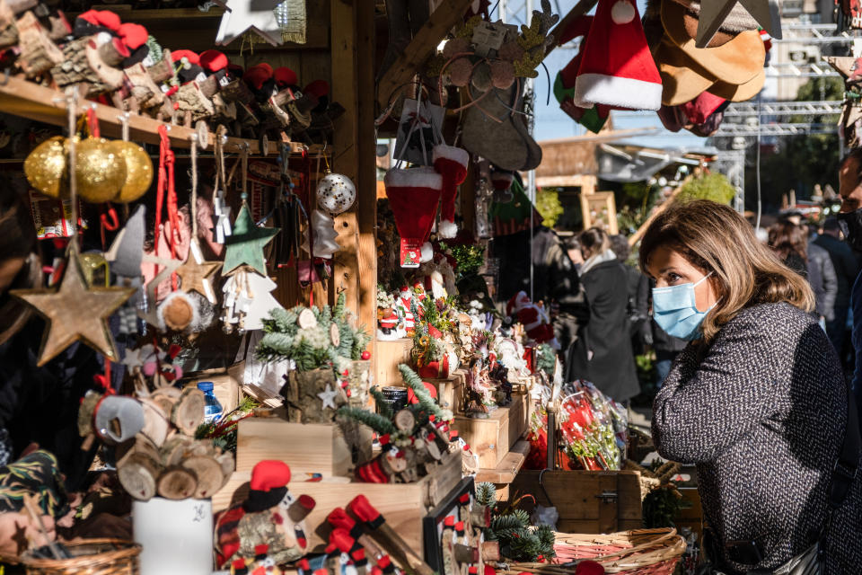 A woman wearing a face mask is seen shopping in the popular Christmas market known as Fira de Santa Ll&#x00fffd;cia. Many people take advantage of the second non-working day with stores opening, to shop in anticipation for Christmas. Shoppers are seen wearing protective facemasks due to the surge Covid-19 infections. (Photo by Paco Freire / SOPA Images/Sipa USA)