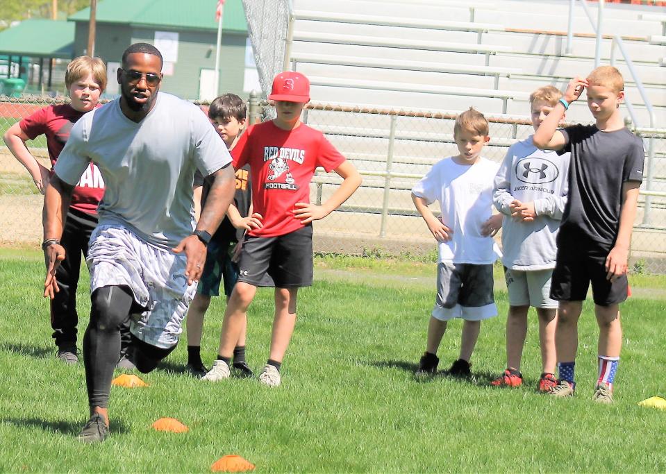 Former New England Patriot running back Jonas Gray demonstrates his moves for his students during a Saturday, May 13, 2023 clinic at Roger Allen Park in Rochester. Pictured from left to right are Boston Otting, Shane Donald, Seth Allen, Landon Barrett, Drew Reilly and Mason Wattles.