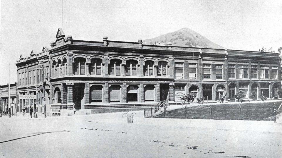 An undated photo that shows the completed Andrews Bank and related buildings completed by 1906. There is a bicycle and utility poles in the photo but no cars.