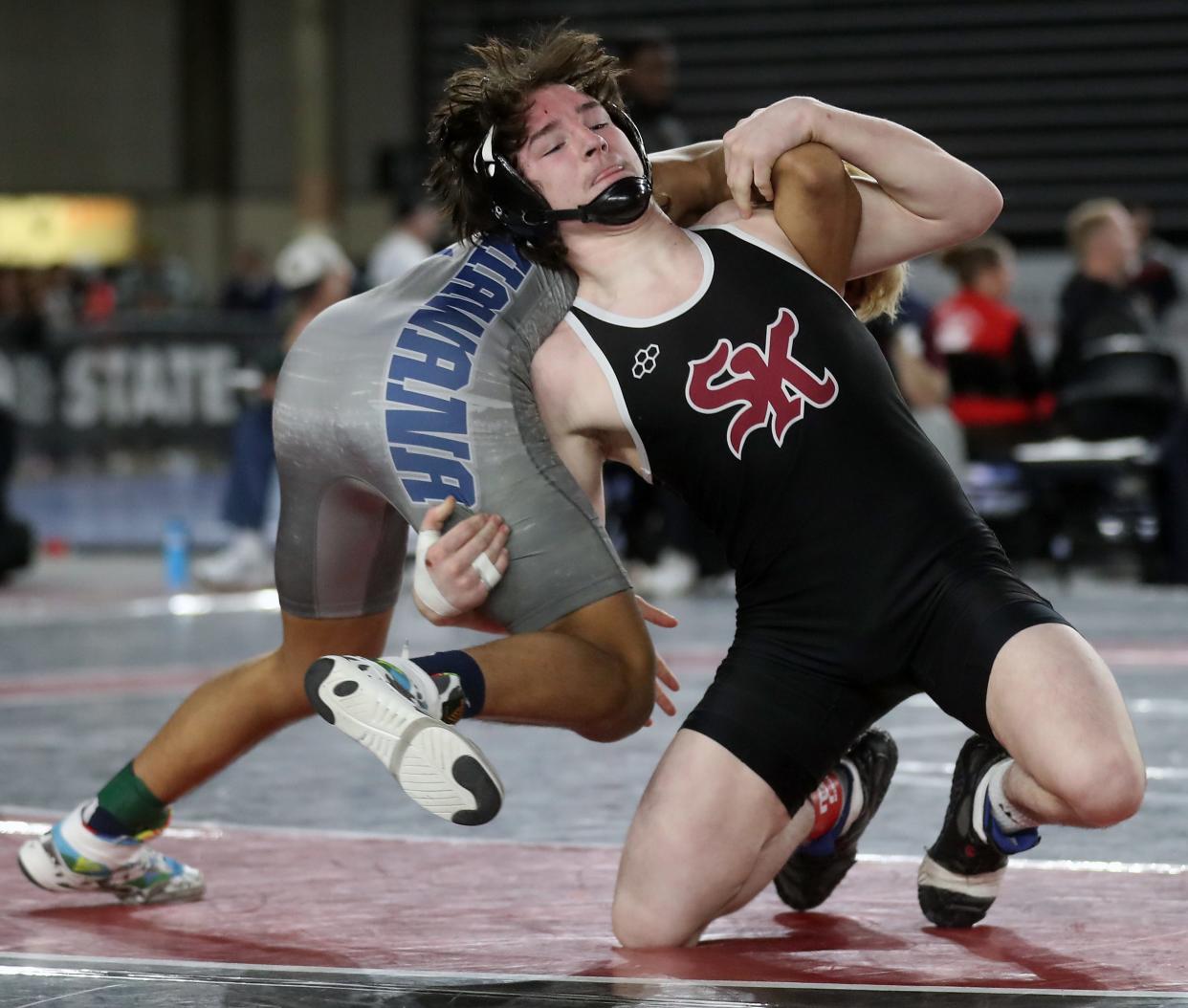 South Kitsap’s Stone Hartford wrestles Chiawana’s Jordan Tobias in the 144-pound championship bout at Mat Classic on Friday, Feb. 17, 2024.