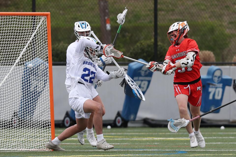 Mamaroneck's Alex Martin (31) gets a shot past Bronxville goalie Luke Arrighi (22) for a second half goal during boys lacrosse action at Bronxville High School April 21, 2022. Mamaroneck won the game 14-8.
