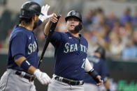 Seattle Mariners' Ty France (23) is congratulated by Eugenio Suarez after France scored on a sacrifice fly by Suarez during the first inning of the team's baseball game against the Texas Rangers in Arlington, Texas, Saturday, Aug. 13, 2022. (AP Photo/LM Otero)