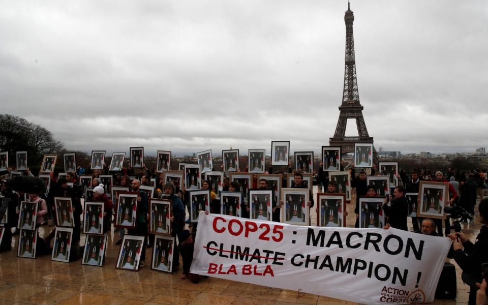 Activists hold portraits of President Emmanuel Macron to urge France to take action during the U.N. COP 25 climate talks in Madrid in December 2019 - Francois Mori/AP