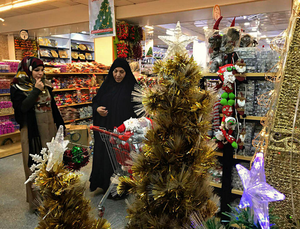 Iraqis shop for Christmas decorations in Baghdad, Iraq, Monday, Dec. 24, 2018. Although the number of Christians has dropped in Iraq, Christmas, a national holiday, is very popular in the capital. (AP Photo/Ali Abdul Hassan)