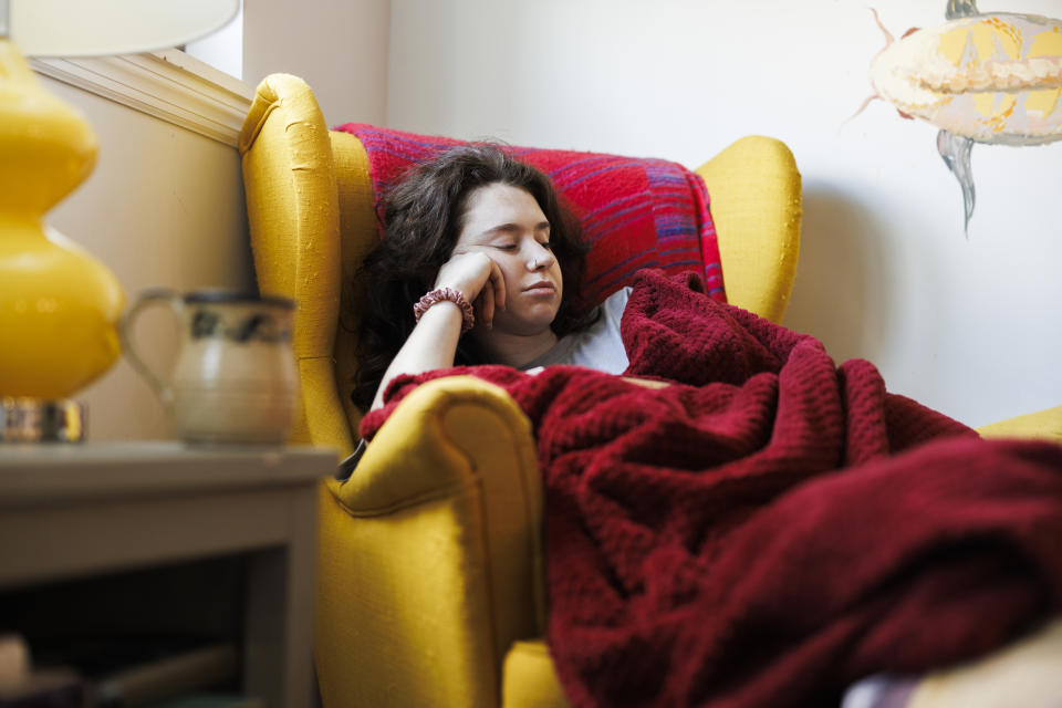 Person resting on a chair with a blanket